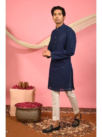 A full view of my classic navy blue festive kurta, crafted with traditional chikankari and highlighted with subtle mirror work. It's a versatile and elegant option for Diwali celebrations or family gatherings, paired here with white trousers and classic loafers.