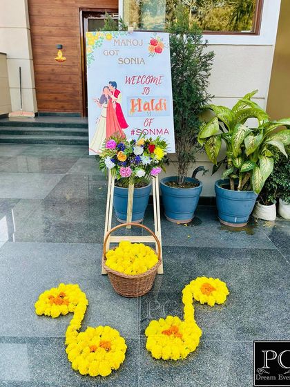 Welcoming guests to the Haldi ceremony with a personalized sign and floral arrangements. I used marigold flowers to create musical notes on the ground for a unique, creative touch.