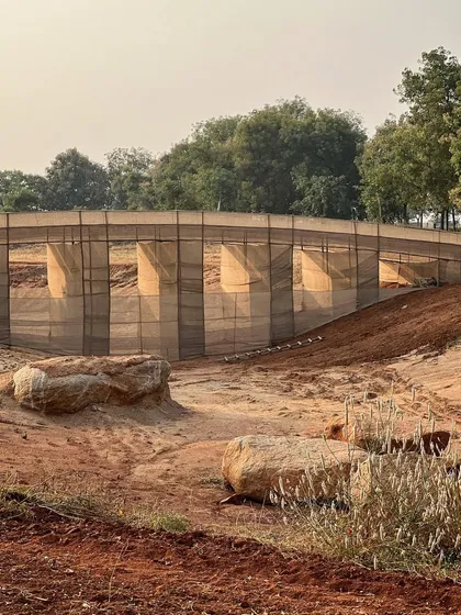 The temporary jute bridge mock-up seen from a distance. While the final piece will be made of stone, this ephemeral version allows us to study its visual impact on the horizon.