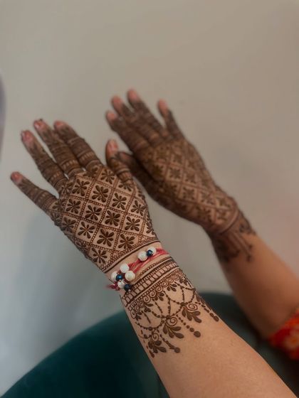A beautiful shot of a Rakhi mehandi, with the rakhi tied on the wrist. The design is a classic jaal pattern.