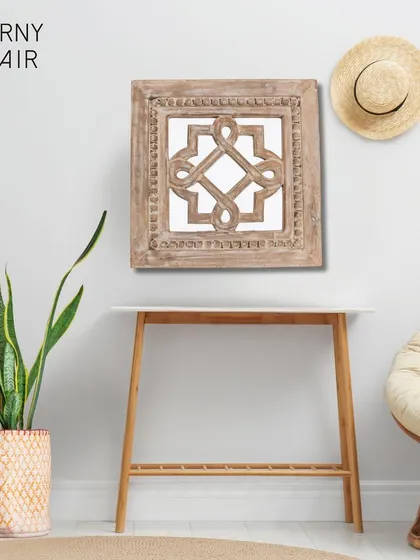 This square wooden wall art features a beautiful, hand-carved geometric knot design. It is a wonderful way to add texture and a touch of traditional Indian artistry to a gallery wall or a quiet corner of your home.