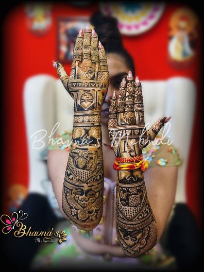 Here you can see the full bridal mehndi, with both hands held up to show the complete design. The artwork is dense and rich, covering the arms with traditional figures and patterns, perfect for the bride who wants a classic look.