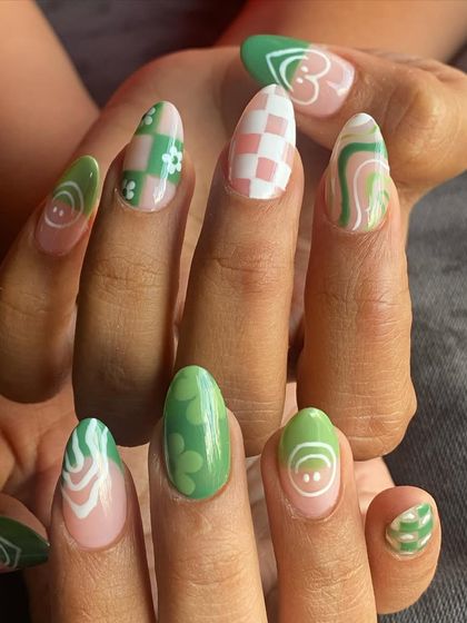 A full view of both hands, showcasing the variety of designs in this playful green and pink nail art set.