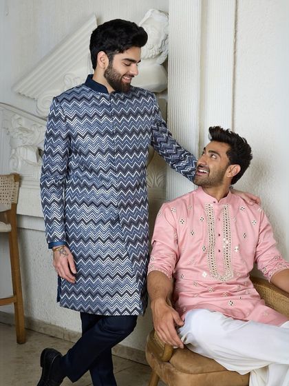 A candid moment showcasing two different but complementary styles. The structured chevron kurta contrasts beautifully with the soft, draped pink kurta.