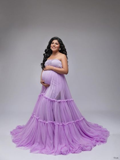 A full-length standing portrait in the lavender gown, showcasing its beautiful flow and soft color against a clean white background.