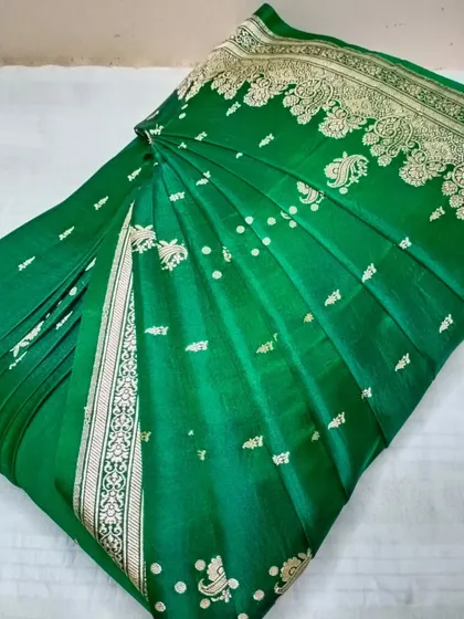 A green Banarasi saree, pre-pleated and ready to be draped.