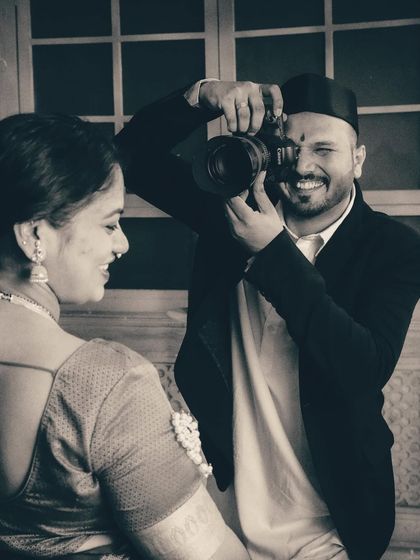 A close-up capturing the husband's joyful expression as he frames a shot of his wife. This image highlights the fun and collaborative spirit I encourage during every creative maternity photoshoot.