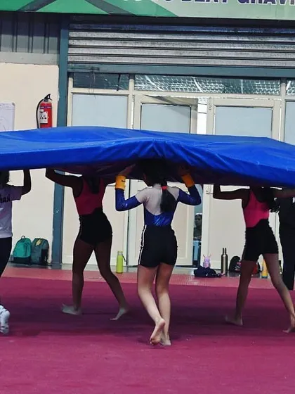 Teamwork makes carrying the heavy mats easier. Our students learn to work together in and out of their routines.