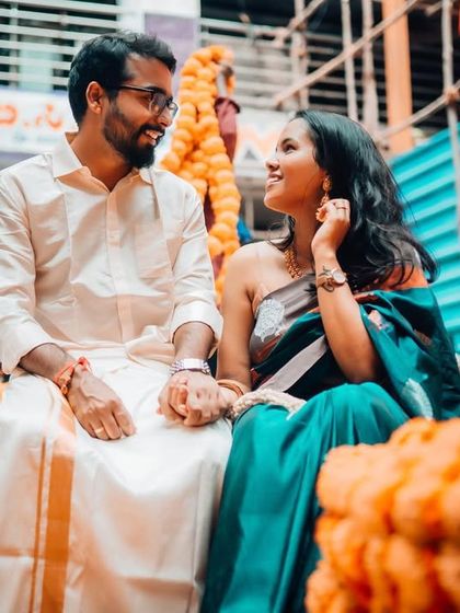 Seated amidst garlands of marigolds, this couple shares a loving look. This pre-wedding shot beautifully incorporates traditional elements in a contemporary way.