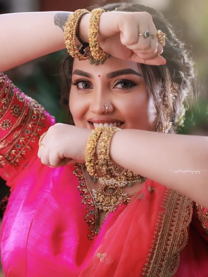 A playful close-up where the bride frames her face with her hands. Her smile is bright and infectious.