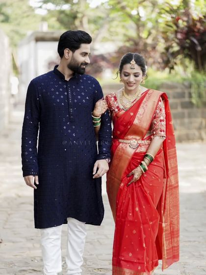 A classic walking shot of the engaged couple, showcasing their traditional yet stylish engagement outfits.