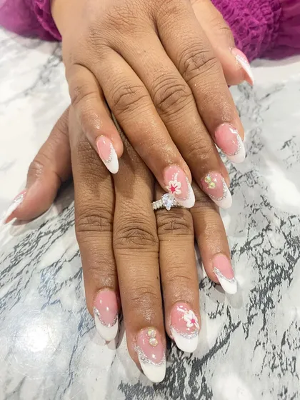 A beautiful French manicure with a twist. This set includes delicate lace-like details and pearl accents, perfect for a bride who wants a classic but unique design.