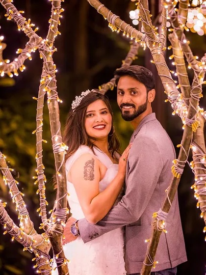 A close-up portrait within the fairy-lit trees, capturing a moment of intimacy and joy.