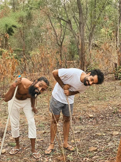 This is a duplicate of image 11. Two students share a laugh while working in the woods, showing that even service (seva) can be filled with joy.