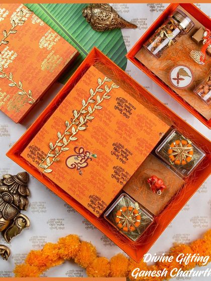 Divine gifting for Ganesh Chaturthi bliss. This sacred hamper in auspicious orange includes a Ganpati idol, laddus, jars of almonds, and other items for prayer and celebration.
