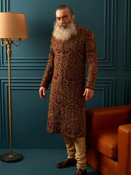 A full-length view of the maroon velvet embroidered sherwani. This outfit is designed to make a powerful impression, perfect for a groom who wants a truly royal look.