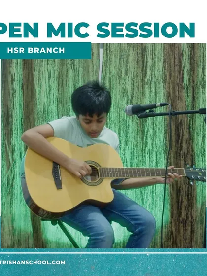 A photo from our HSR branch open mic, showing a student playing an acoustic guitar.
