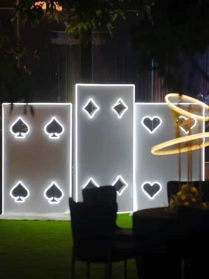 Large, illuminated playing card installations serve as a fun, thematic backdrop for a Diwali party. These custom light-up props are perfect for photo opportunities and reinforcing a casino or card party theme.