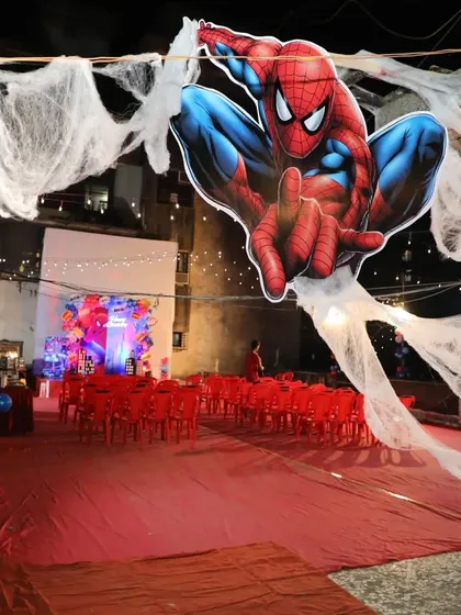 The entire venue was transformed into Spider-Man's web-slinging world. This wide shot shows the themed seating area and a giant Spider-Man cutout suspended overhead.