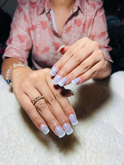 A beautiful glittery take on the French manicure. These square-shaped extensions feature a sparkling silver glitter base with crisp white tips.