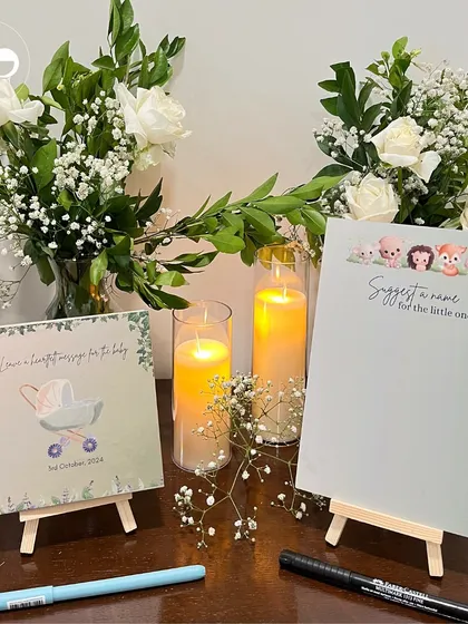 A clean and simple setup for the guest activity table at an in home baby shower. The minimalist design, with fresh flowers and soft candlelight, creates a welcoming space for guests to leave their wishes.