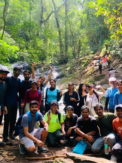 A group photo in a dense forest section of the trail, with a small stream in the background.