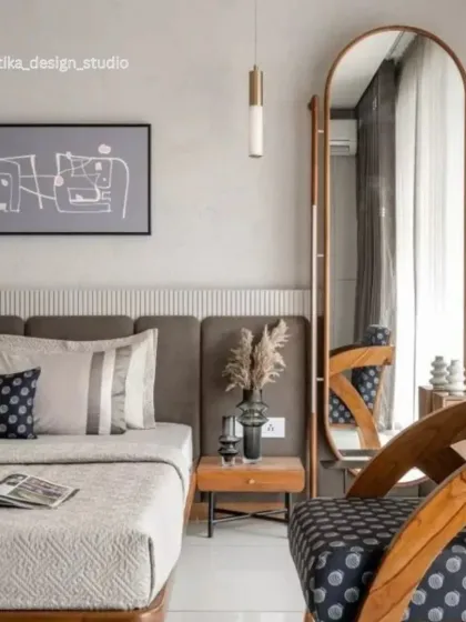 This view includes the accent chair and the full-height arched mirror, which adds a sense of elegance and makes the room feel larger. The mix of patterns, from the chair's upholstery to the cushions, adds a layer of curated detail to the minimalist design.