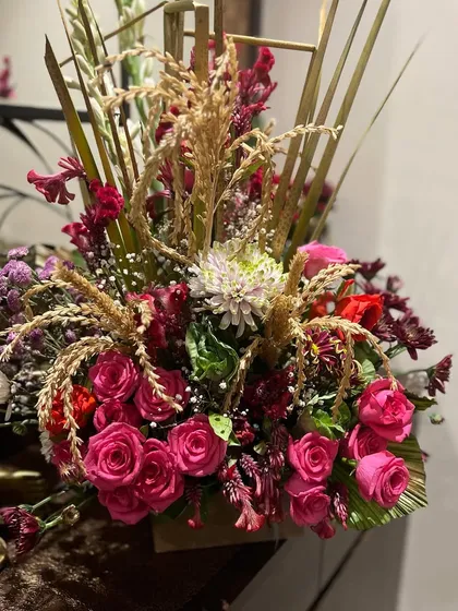 Getting into the festive vibes with this rustic arrangement. We combined pink roses, chrysanthemums, and dried wheat stalks for a unique, celebratory look perfect for Diwali or other holidays.