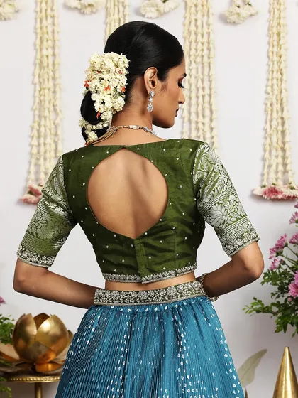 A detailed shot of the back of the green blouse, showing the keyhole design and intricate brocade sleeves.