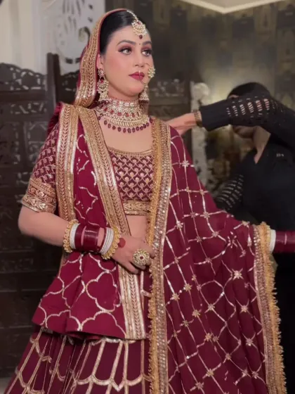 A client getting ready in a deep maroon peplum-style lehenga. The unique silhouette is modern and flattering.