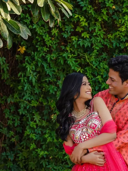 A sweet, candid moment between the couple against a lush green backdrop. The way they look at each other tells a story of love and happiness.