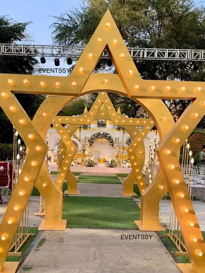 A creative star-shaped archway entrance that perfectly frames the royal castle in the distance. This layered approach to decor builds excitement as guests walk through the event space.