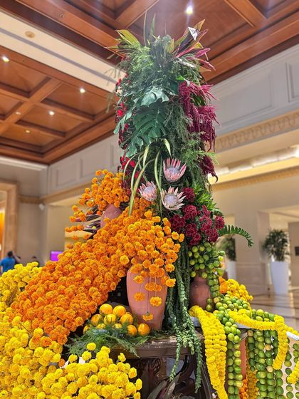 Another angle of the lobby installation, showing the inclusion of lotus buds and other exotic flowers among the cascading marigolds. The design is a testament to the beauty and abundance of nature.
