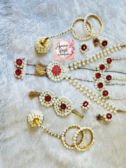 A classic halwa jewellery set in white with red accents. This collection includes a hair clip, rings, and bangles.