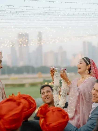 The varmala exchange against the backdrop of the city skyline and a canopy of fairy lights. My designs often blend the natural or urban environment with curated decor for a unique setting.