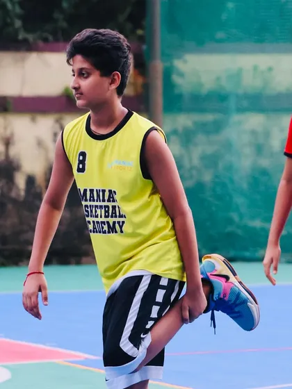 A young player stretches before a drill. We emphasize proper warm-ups to ensure our athletes are ready for intense training.