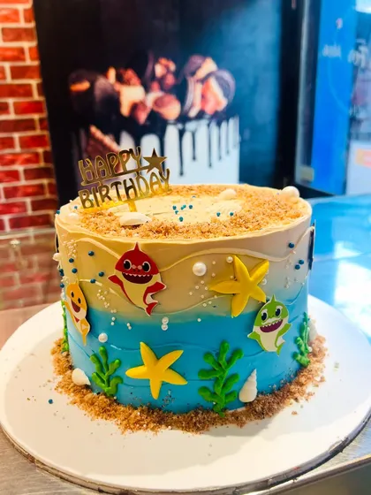 A fun Baby Shark cake with an underwater beach theme, perfect for a young fan.