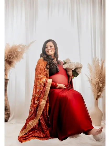 A lovely portrait that highlights the intricate details of the traditional attire and the natural beauty of the mom-to-be.
