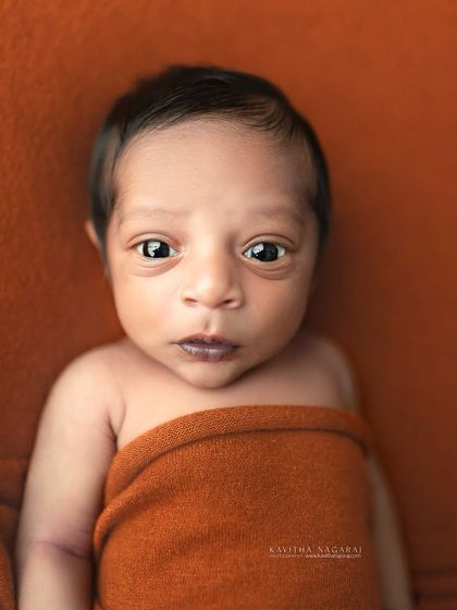 An adorable awake shot of a seven-day-old newborn. Capturing these moments of eye contact is a beautiful way to see their personality begin to emerge.