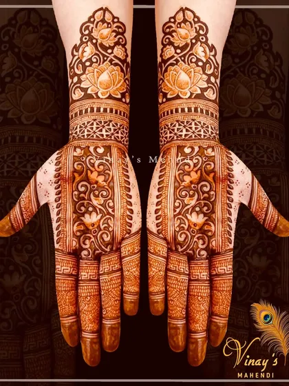 A beautiful symmetrical design with intricate floral and paisley patterns. The stained hands show the beautiful color our henna leaves behind.