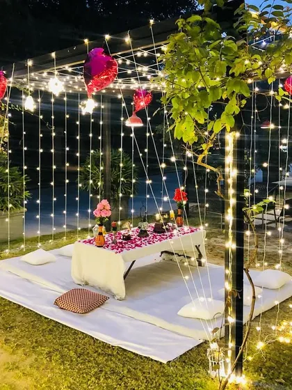 This image shows the intimate dinner arrangement inside our garden cabana proposal setup. The space is enclosed by curtains of fairy lights, creating a magical atmosphere for a private celebration.
