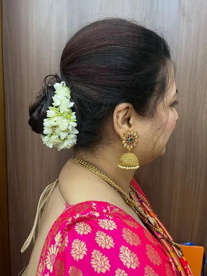 A side view of this elegant and fancy bun, beautifully adorned with a string of fresh mogra gajra for a traditional fragrance and look.