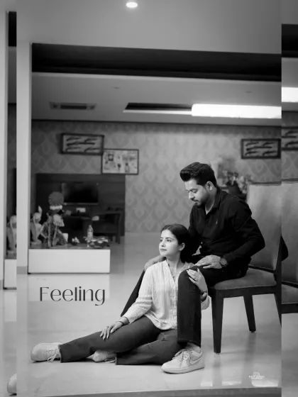 A tender black and white portrait of the couple in a modern living room, capturing a quiet, intimate moment with the word "Feeling" overlaid.