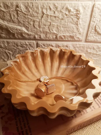 The floral bowl in "Mocha Mousse" is perfect for holding delicate jewelry. The warm, neutral tones of the marble complement both gold and silver accessories.