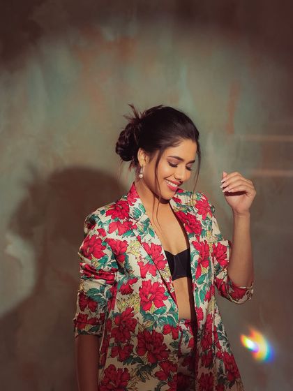 A dynamic and happy shot of Karunya. Her messy bun and playful pose give off a fun and energetic vibe.