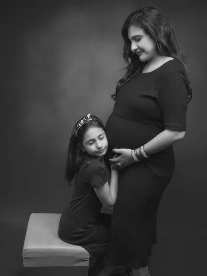 A big sister's gentle hug for her unborn sibling. This black and white portrait is filled with tenderness and anticipation. It’s a quiet, beautiful moment that speaks volumes about the love in this growing family.