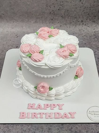 A two-tiered vintage floral cake with delicate white and pink piping. This butterscotch-flavored cake is a classic choice for any birthday.