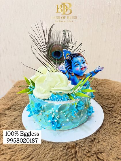 This Janmashtami cake features a joyful Bal Krishna figurine with a real peacock feather and delicate frosting flowers. It's a wonderful way to add sweetness to your festive prayers.