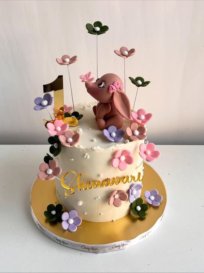 A full view of the first birthday cake for Sharvari, showcasing the elegant and whimsical design.
