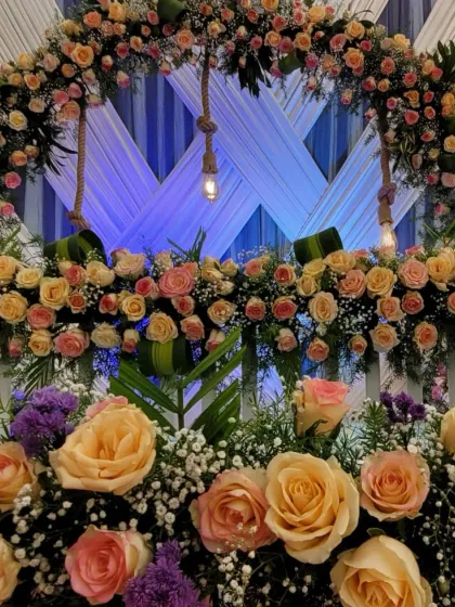A detailed shot showing the variety of flowers, including roses and baby's breath, used to create the dense floral arch.